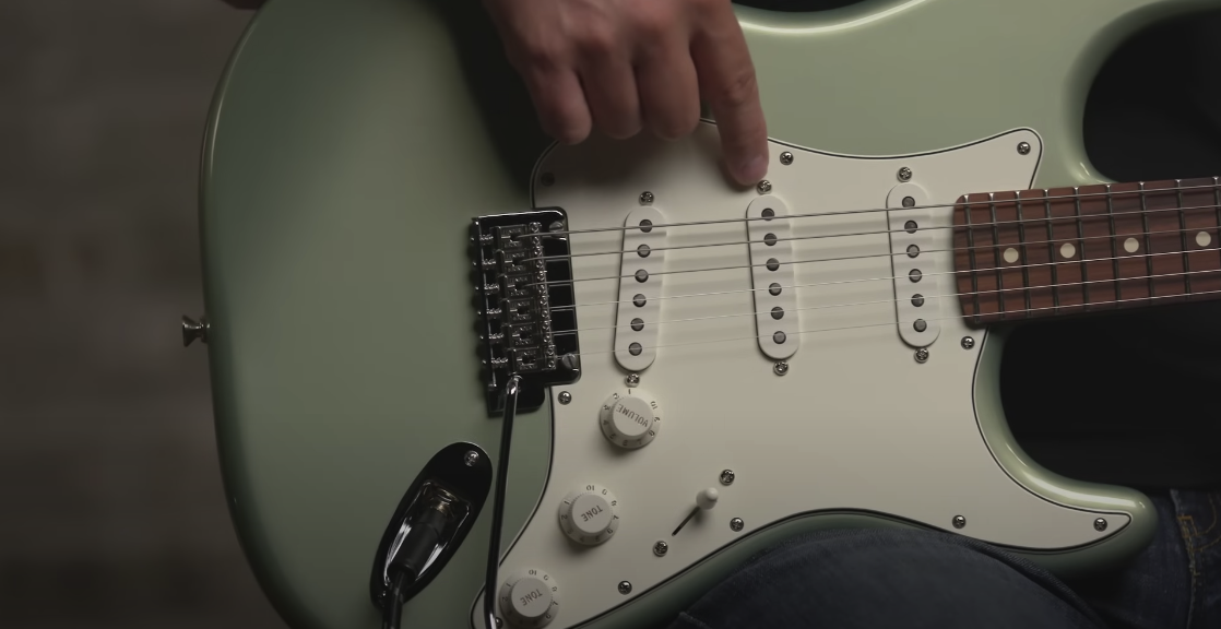 Close-up view of the body of a green guitar