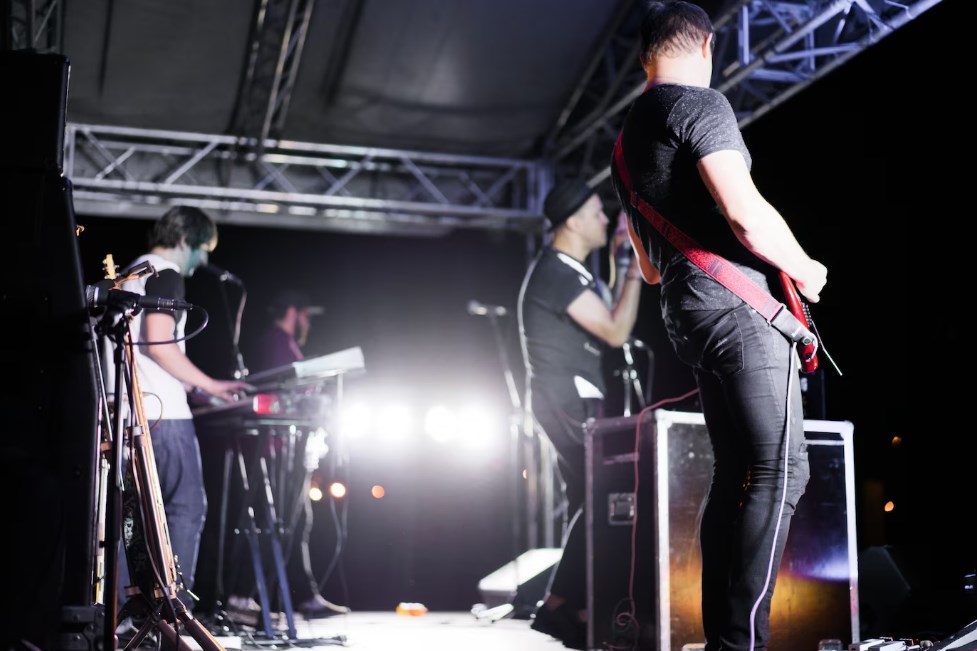 four musicians performing on stage during a live concert