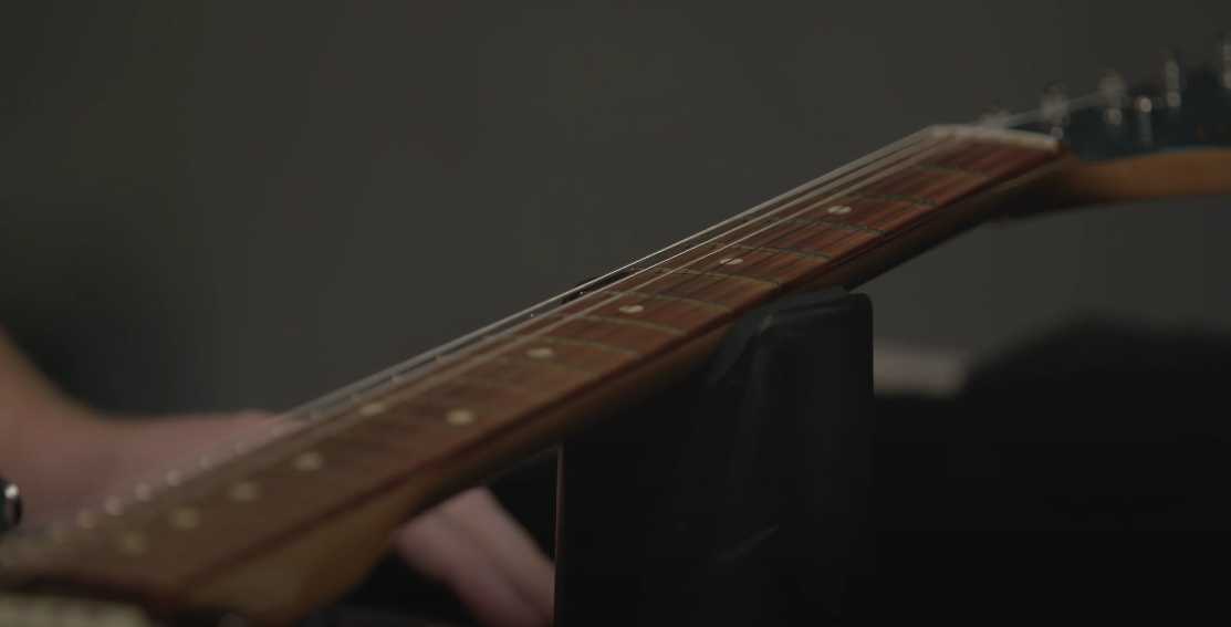 Photo of a guitar, with a focus on the guitar fretboard