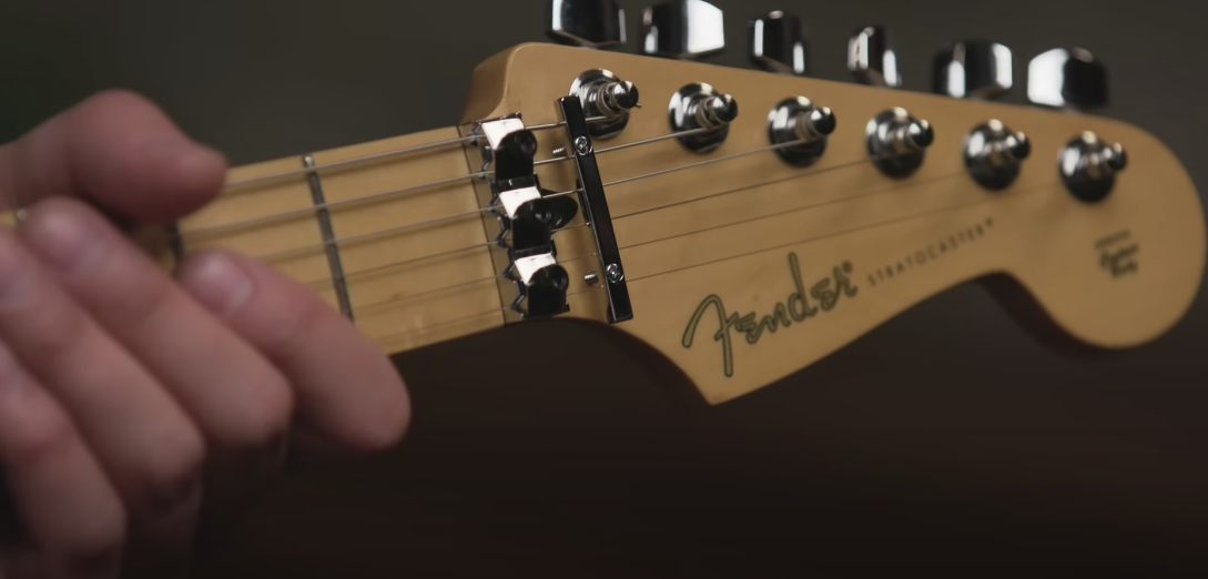 Close-up view of the headstock of a green guitar