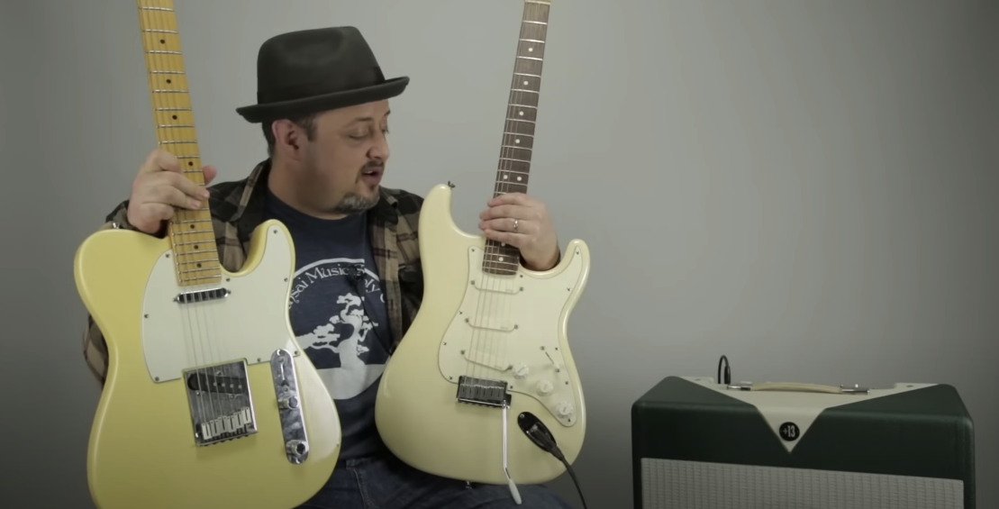 Photo of a man holding two Fender Stratocaster guitars on his lap